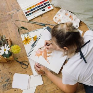 Young woman drawing watercolour illustration.