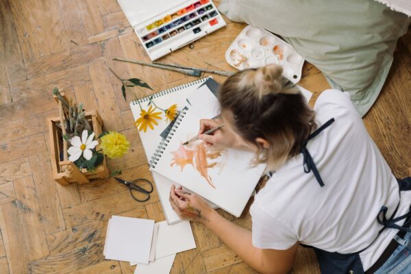 Young woman drawing watercolour illustration.